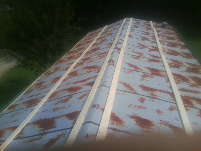 Rusted metal roof panels with new wood purlins before replacement — Storm Damage Roof Repair in Portsmouth by Roofing Brothers